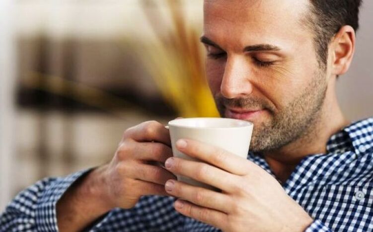Un hombre bebe un trago de té de fireweed para aumentar la potencia. 